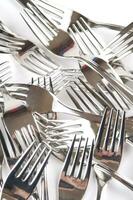 many forks and knives are arranged in a pile photo