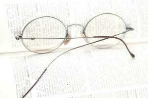 a pair of glasses is sitting on top of an open book photo
