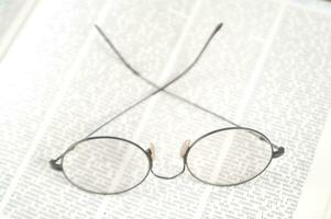 a pair of glasses is sitting on top of an open book photo