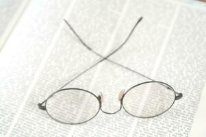 a pair of glasses is sitting on top of an open book photo