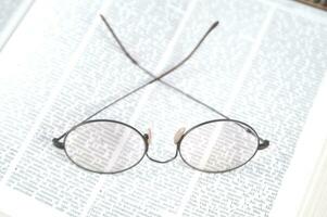 a pair of glasses is sitting on top of an open book photo