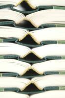 a stack of open books with green and gold trim photo