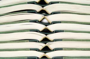 a stack of open books with green and gold trim photo