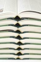 a stack of open books with green and gold trim photo