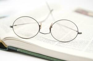 a pair of glasses is sitting on top of an open book photo