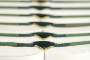 a stack of open books with green and gold trim photo