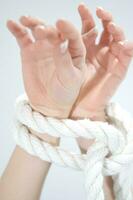 a woman's hands are tied to a rope photo