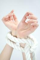 a woman's hands are tied to a rope photo