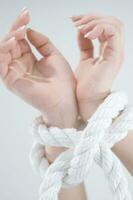 a woman's hands are tied to a rope photo