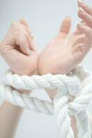 a woman's hands are tied to a rope photo