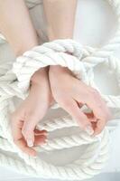 a woman's hands are tied to a rope photo