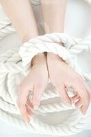 a woman's hands are tied to a rope photo