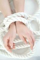 a woman's hands are tied to a rope photo