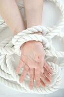 a woman's hands are tied to a rope photo