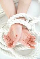 a woman's hands are tied to a rope photo