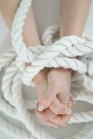 a woman's hands are tied to a rope photo