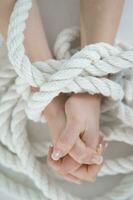 a woman's hands are tied to a rope photo