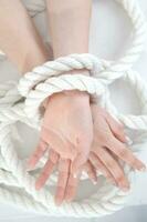 a woman's hands are tied to a rope photo