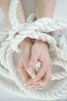 a woman's hands are tied to a rope photo