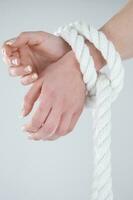 a woman's hands are tied to a rope photo