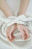 a woman's hands are tied to a rope photo