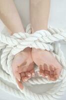 a woman's hands are tied to a rope photo