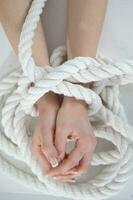 a woman's hands are tied to a rope photo