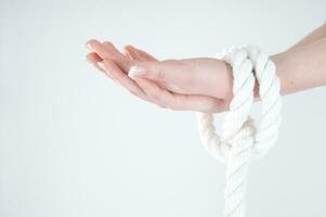 a woman's hands are tied to a rope photo