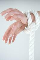 a woman's hands are tied to a rope photo