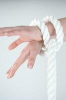 a woman's hands are tied to a rope photo