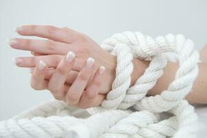 a woman's hands are tied to a rope photo