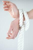 a woman's hands are tied to a rope photo