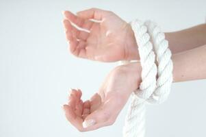 a woman's hands are tied to a rope photo