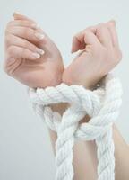 a woman's hands are tied to a rope photo