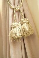 two tassels hanging from a curtain rod photo