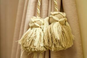 two tassels hanging from a curtain rod photo