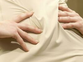 a woman is holding her stomach photo