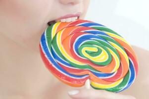 a woman holding a large lollipop photo