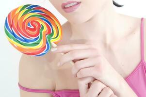 a woman holding a large lollipop photo