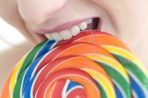 a woman holding a large lollipop photo