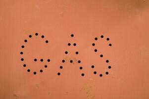 a gas station sign with holes in it photo
