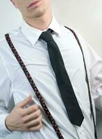 a man in a black suit and tie looking down photo