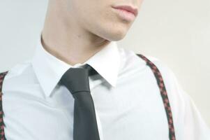 a man in a black suit and tie looking down photo