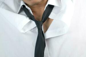 a man in a suit and tie standing against a wall photo