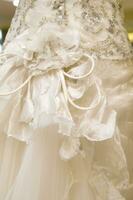 a close up of a wedding dress with a bow photo