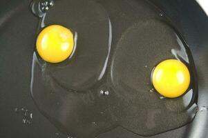four eggs are being cooked in a frying pan photo