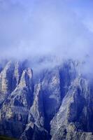 a mountain with a cloud covered sky photo