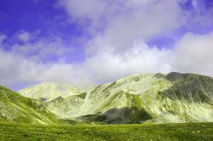 a mountain with a cloud covered sky photo