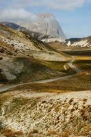 un la carretera devanado mediante un montaña rango foto