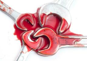three wrenches with red liquid on them photo